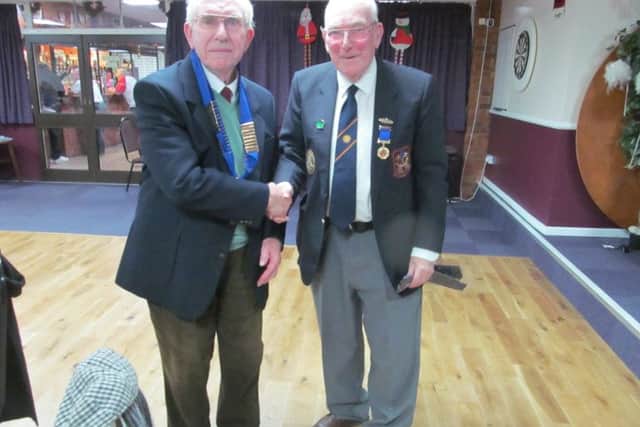 New Peterborough League president Gordon Stirman (left) received the chain of office from outgoing president Dick Gill.