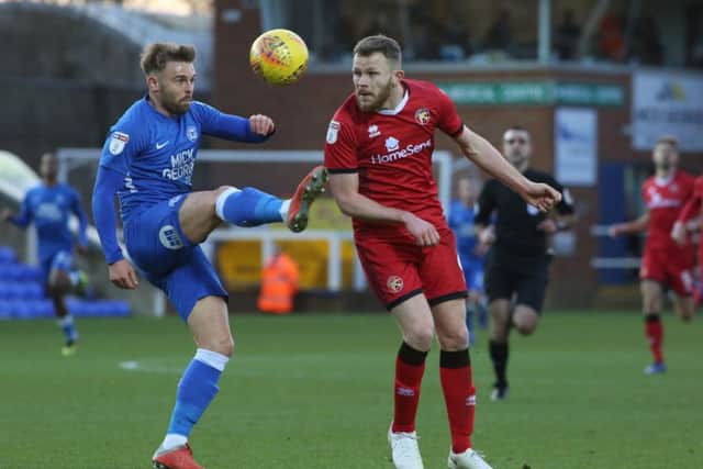 Matt Godden of Peterborough United in action with Nicky Devlin of Walsall. Photo: Joe Dent/theposh.com.