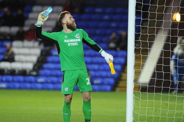 Scunthorpe goalkeeper Jak Alnwick with a bottle that appeared to be thrown at him from the London Road End. Photo: David Lowndes.