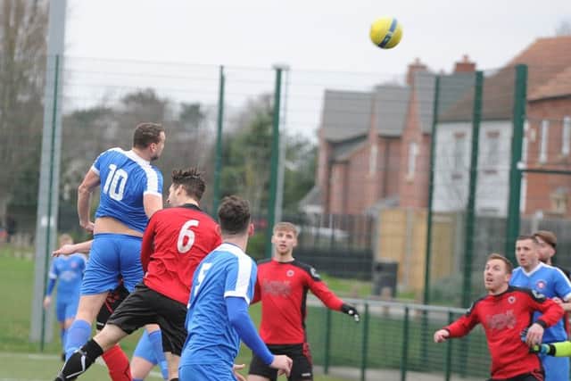 Matt Heron (10) of Whittlesey Athletic wins this aerial battle in the Peterborough Senior Cup quarter-final at Netherton. Photo: David Lowndes.