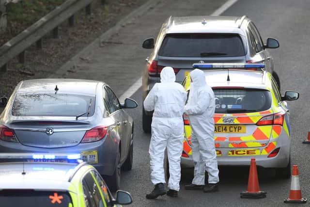 Police examining the Vauxhall Insignia. Photo: Joe Giddens/PA