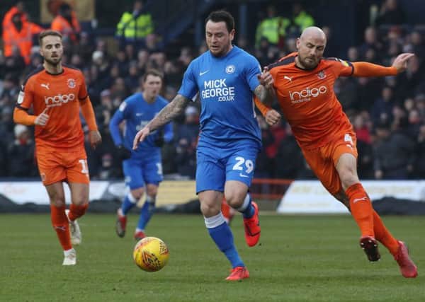 Lee Tomlin of Peterborough United in action with Alan McCormack of Luton Town. Picture: Joe Dent