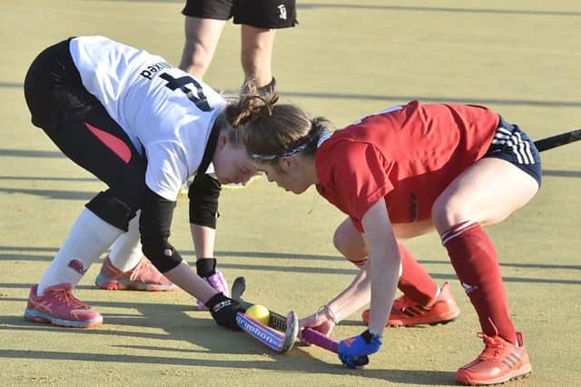 Ellie Bolsover of City of Peterborough (red) battles for possession agains Harleston in the National Mixed Cup. Photo: David Lowndes.