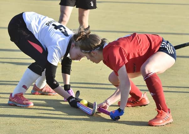 Ellie Bolsover of City of Peterborough (red) battles for possession agains Harleston in the National Mixed Cup. Photo: David Lowndes.