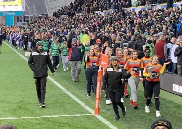 Borough Under 15 Girls captain Jas Murray parades the trophy at half-time during the local derby between Northampton Saints and Leicester Tigers.