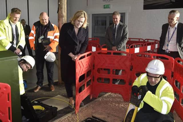 Amber Rudd MP watches as engineers explain a typical repair to services.