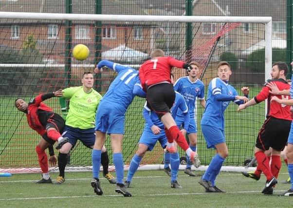 Action from Whittlesey's recent win at Netherton (red) n the Peterborough Senior Cup.