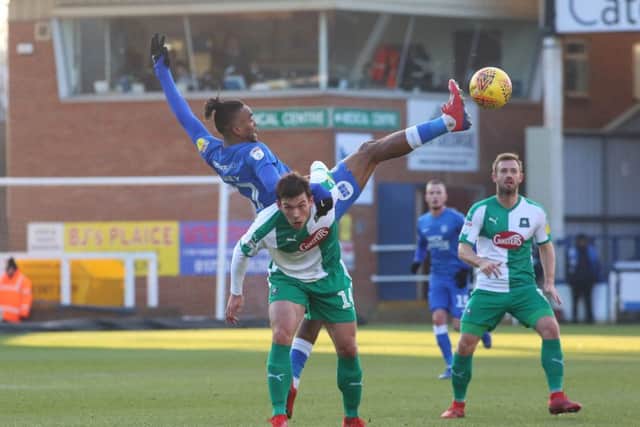 Ivan Toney of Peterborough United challenges for the ball with Niall Canavan of Plymouth Argyle. Photo: Joe Dent/theposh.com.