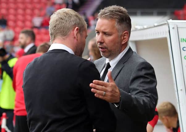Darren Ferguson (right) shakes hands with Grant McCann ahead of Doncaster v Posh last season.