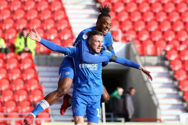 George Cooper celebrates his goal for Posh at Doncaster with Ivan Toney.
