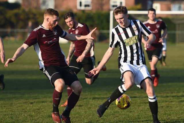 Tom Mann of Peterborough Northern Star (stripes) in action against Holbeach United. Photo: Chantelle McDonald. @cmcdphotos.