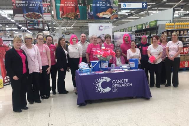 Tesco staff with local Cancer Research UK volunteers at their 2018 'Tesco Turns Pink' in-store fundraiser