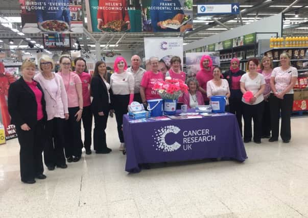 Tesco staff with local Cancer Research UK volunteers at their 2018 'Tesco Turns Pink' in-store fundraiser