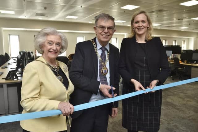 Opening the new offices, Mayor of Peterborough Cllr Chris Ash cuts the ribbon with the Mayoress of Peterborough Doreen Roberts, left, and Coloplast country manager Annemarie van Neck.