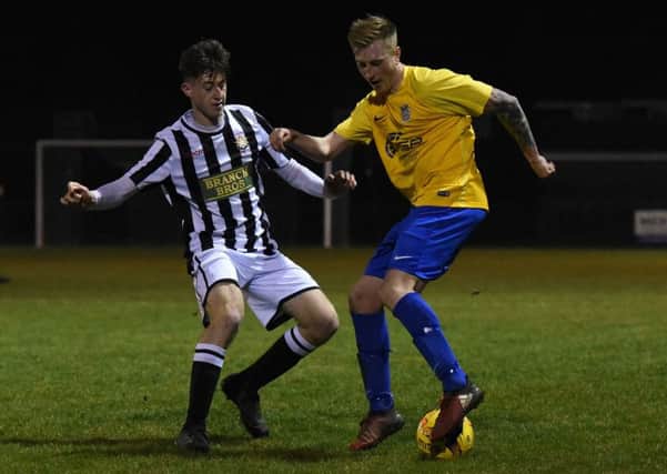 Luke Strachan of Peterborough Northern Star (stripes) in action against Pinchbeck United. Photo: Chantell McDonald. @cmcdphotos.