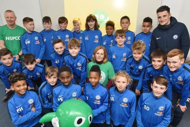 Peterborough United Academy players attending an NSPCC session with volunteers Janice Price and Derrick Mortimer from the NSPCC and academy head of coaching Matt Dye