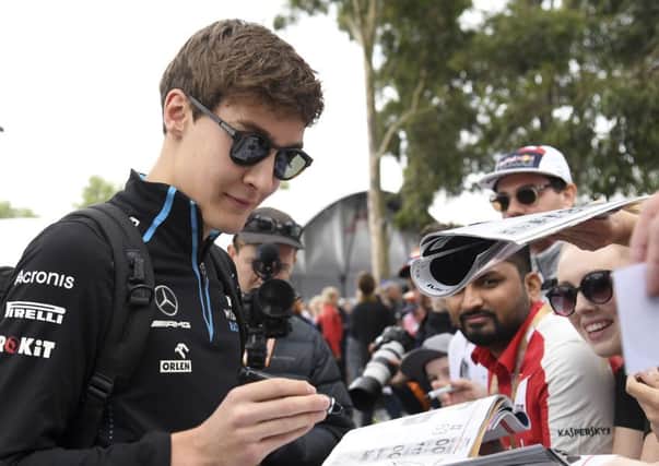 George Russell signs autographs before the Australian Grand Prix.