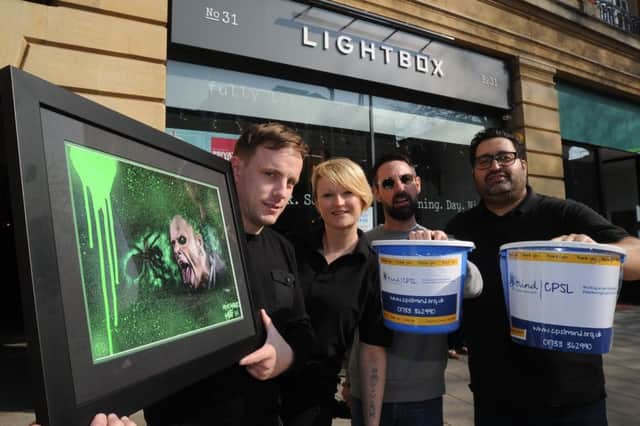 Nathan Murdock with his streetart framed painting  of Keith Flint which is to be auctioned by  Martin Rowe, DJ, Eve Warner, owner of The Lightbox and Zed Malik in aid of MIND EMN-190329-173633009