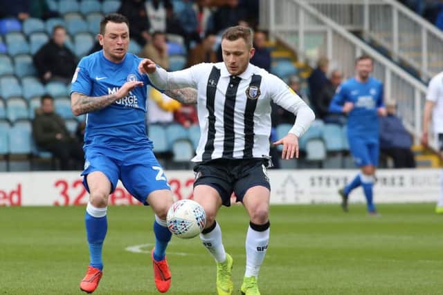 Posh star Lee Tomlin battles for possession with Gillingham's Dean Parrett. Photo: Joe Dent/theposh.com