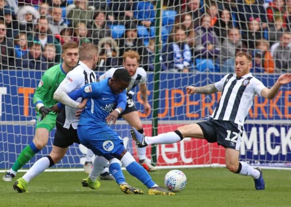 Siriki Dembele of Peterborough United is fouled by Dean Parrett of Gillingham to win a penalty. Photo: Joe Dent/theposh.com.