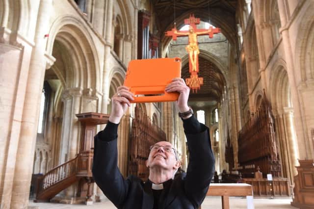 Archbishop of Cantebury  using the new Peterborough Cathedral app with local children. EMN-191004-144753009