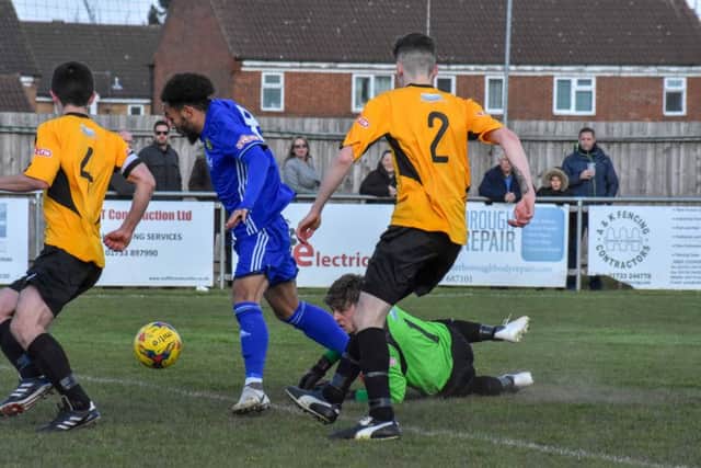 Josh McCammon (blue) scores Peterborough Sports' second goal against Aylesbury. Photo: James Richardson.