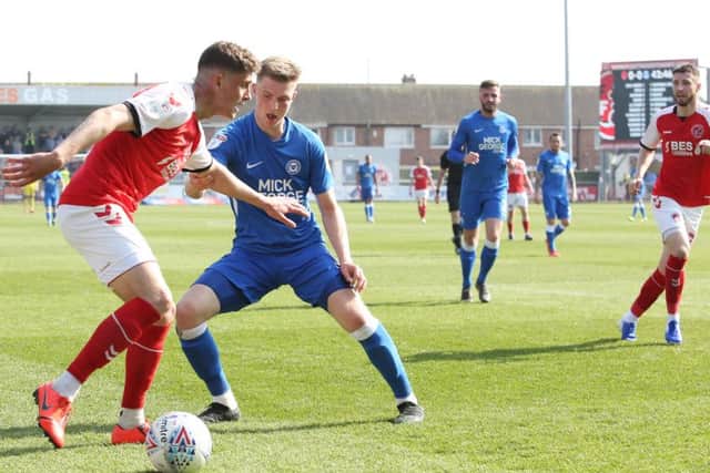 Posh defender Josh Knight puts pressure om Fleetwood's James Husband. Photo: Joe Dent/theposh.com.