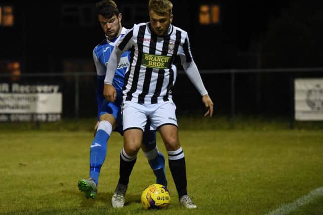 Jake Sansby (stripes) of Peterborough Northern Star in action against Eynesbury Rovers.