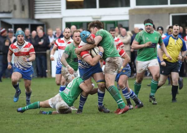 Tom Lewis is tackled high and low against Wharfedale. Picture: Mick Sutterby