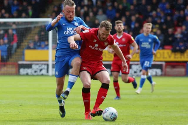 George Cooper of Peterborough United in action with Nicky Devlin of Walsall. Photo: Joe Dent/theposh.com.