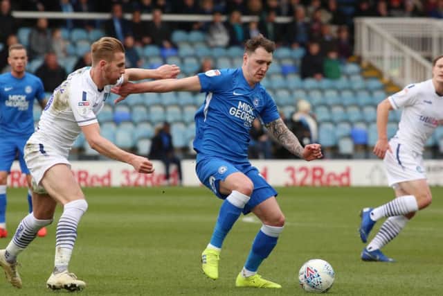 Callum Cooke (blue) in action for Posh.