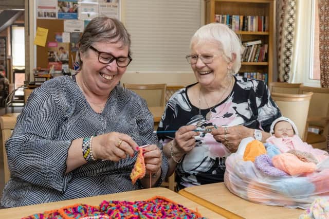 Sheila Steels (left) and Doris Biggs (right) with some of the hats they have knitted for premature babies born at Peterborough City Hospital