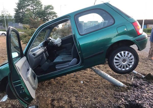 The car suspended on the roundabout. Photo: Cambridgeshire police