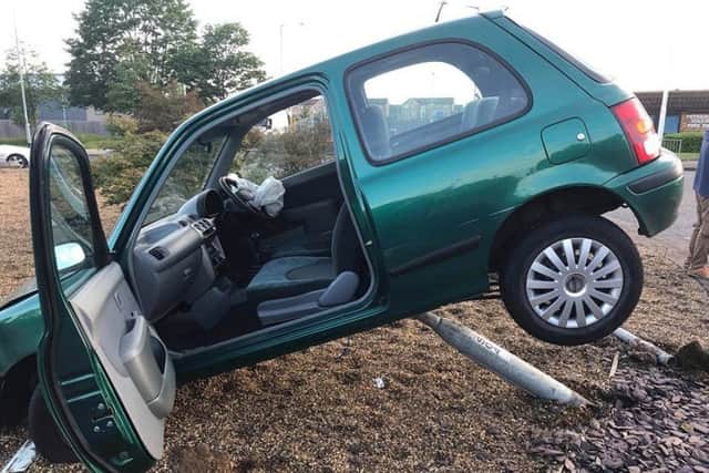 The car suspended on the roundabout. Photo: Cambridgeshire police