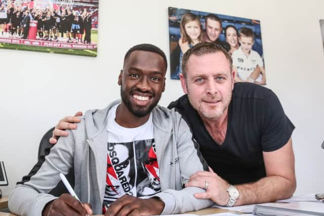 Record Posh signing Mo Eisa with chairman Darragh MacAnthony.