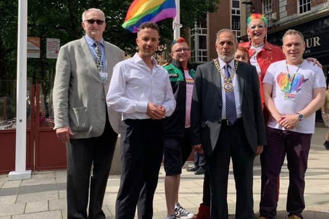 The rainbow flag being raised in Bridge Street