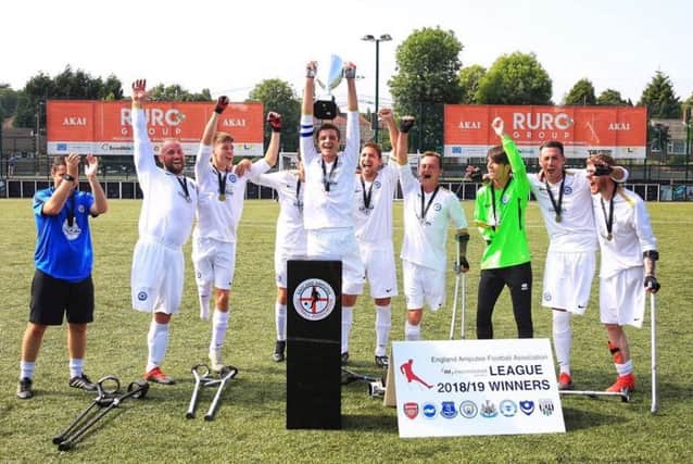 The Peterborough United Amputee players celebrate their triumph. Photo: Peter Burns