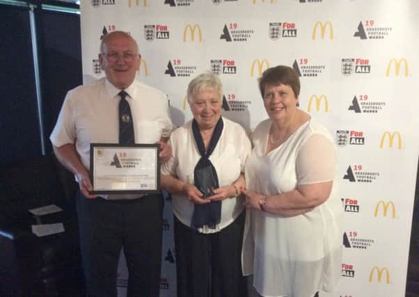 David (Left) and Hazel (centre) Burgess collect the Northants FA 'Grassroots League of the Year' award.