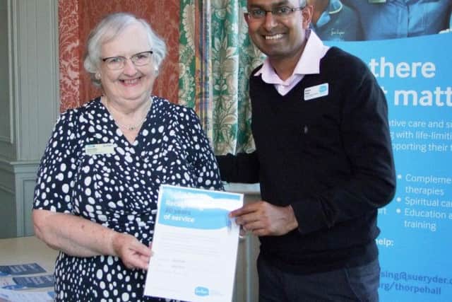 Anne Edis receiving her award for 20 years service from Nilesh Patel, senior community fundraiser
