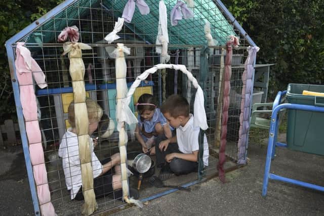 Children using old play equipment at Newborough C of E Primary School
