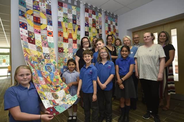 Pupils, staff and parents at Orton Wistow primary school with their 30th anniversary tapestry. EMN-190717-083250009
