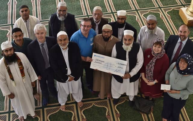 Masjid Ghousia Mosque chairman Nazim Khan presents cheque to David Long from Parkinson's UK in memory of former City coroner Gordon Ryall. Attending with members of the Mosque are coroner David Hemmings , Gillian Beasley and  members of Mr Ryall's family EMN-190913-173818009