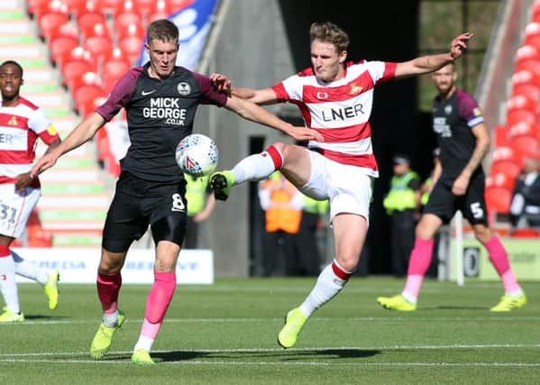 Josh Knight of Peterborough United battles for the ball with Kieran Sadlier of Doncaster Rovers. Photo: Joe Dent/theposh.com./