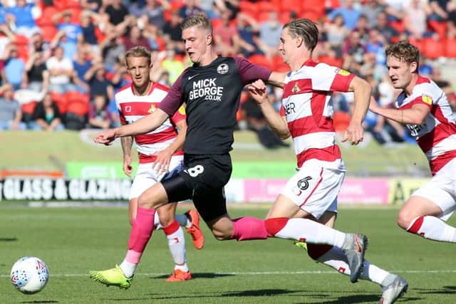 Josh Knight of Peterborough United is closed down by Doncaster Rovers players. Photo: Joe Dent/theposh.com.