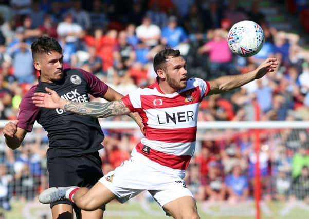 Niall Mason of Peterborough United in action with Jon Taylor of Doncaster Rovers. Photo: Joe Dent/theposh.com