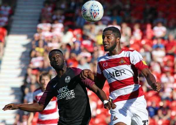 Mohamed Eisa of Peterborough United in action with Cameron John of Doncaster Rover. Photo: Joe Dent/theposh.com.