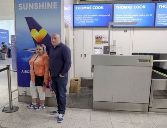Martin Nowell and Pixie Flageul in front of empty Thomas Cook check-in desks at Gatwick Airport in Sussex. Photo: Steve Parsons/PA Wire