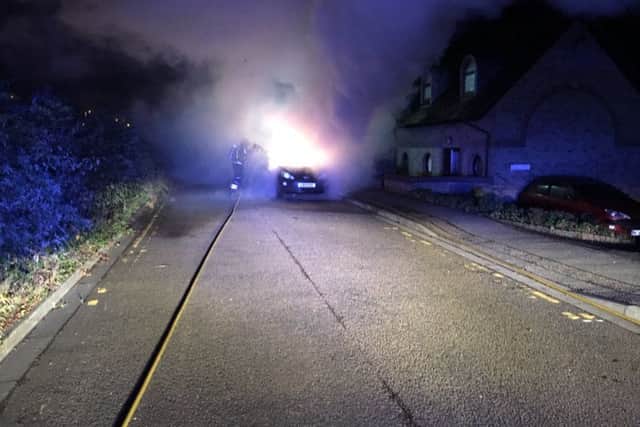 Firefighters tackling the car fire at Ludlow Mews. Photo: Cambridgeshire Fire and Rescue Service