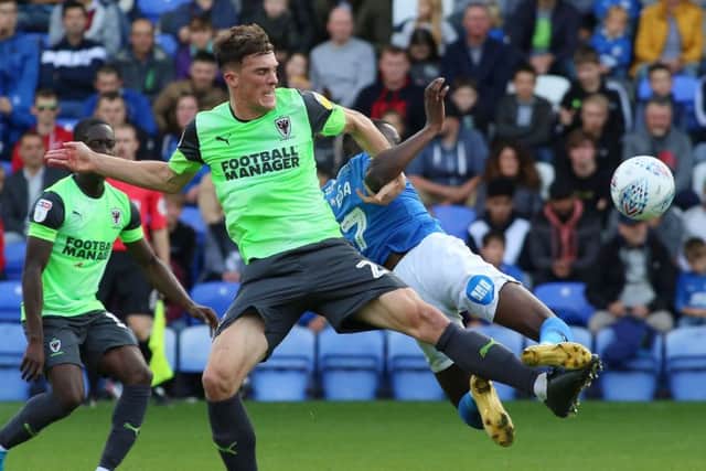 Posh striker Mo Eisa goes down under a heavy challenge from Wimbledon's Ryan Delaney. Photo: Joe Dent/theposh.com.