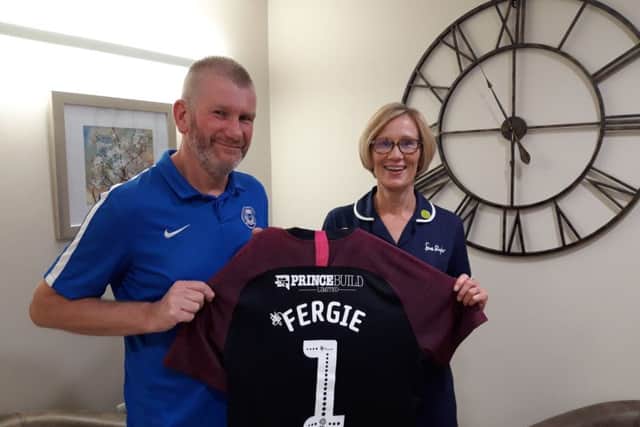 Ian Gow with Sue Ryder nurse Susan Shackleton holding the football top he has had especially printed for his Peterborough United mascot appearance